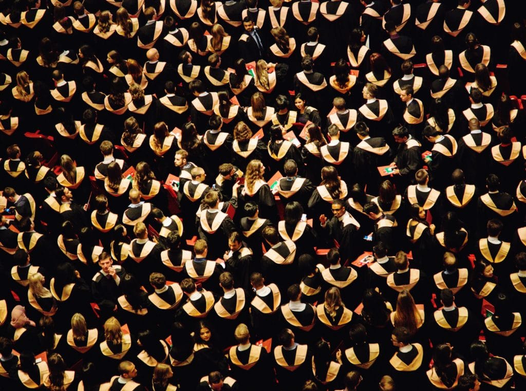 ways to fund your MBA, students sitting at graduation