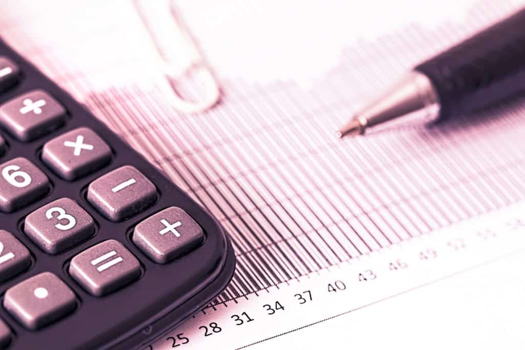 closeup of a calculator and paperwork to illustrate a piece sharing advice about MBA company sponsorship and tuition reimbursement from Valerie Thompkins