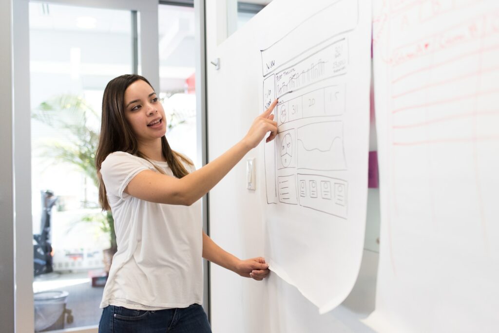 woman presenting to her team, Latina Equal Pay Day #Trabajadoras